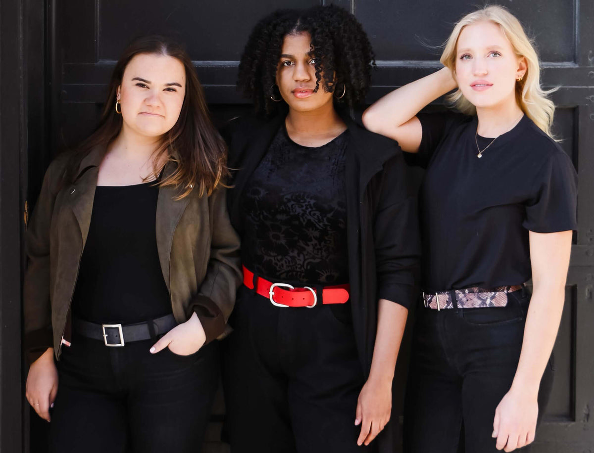 Three women wearing Remo Tulliani belts in black, red and snakeskin-print leather